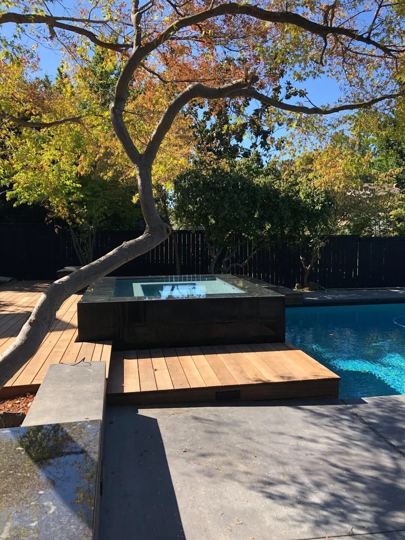 Elevated spa with wood decking and mature trees