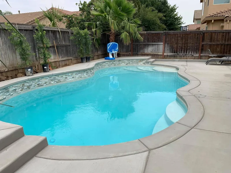 Remodeled freeform pool with new stone coping and deck