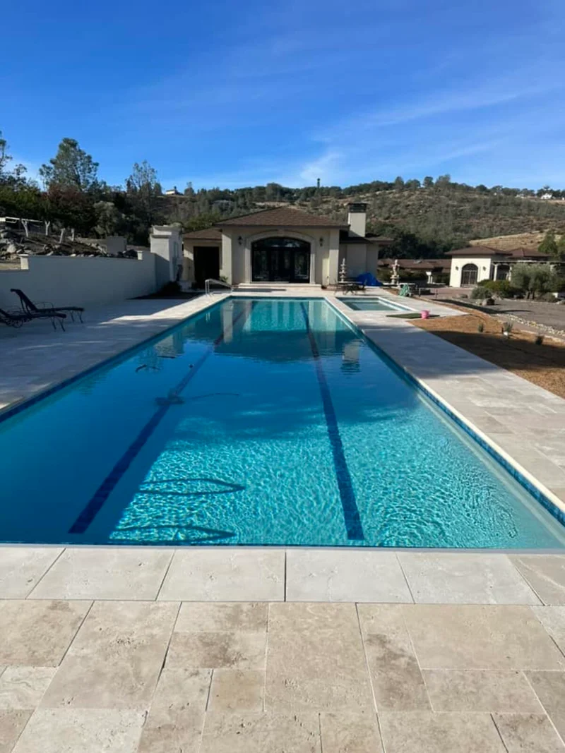 Long lap pool with estate home and rolling hills