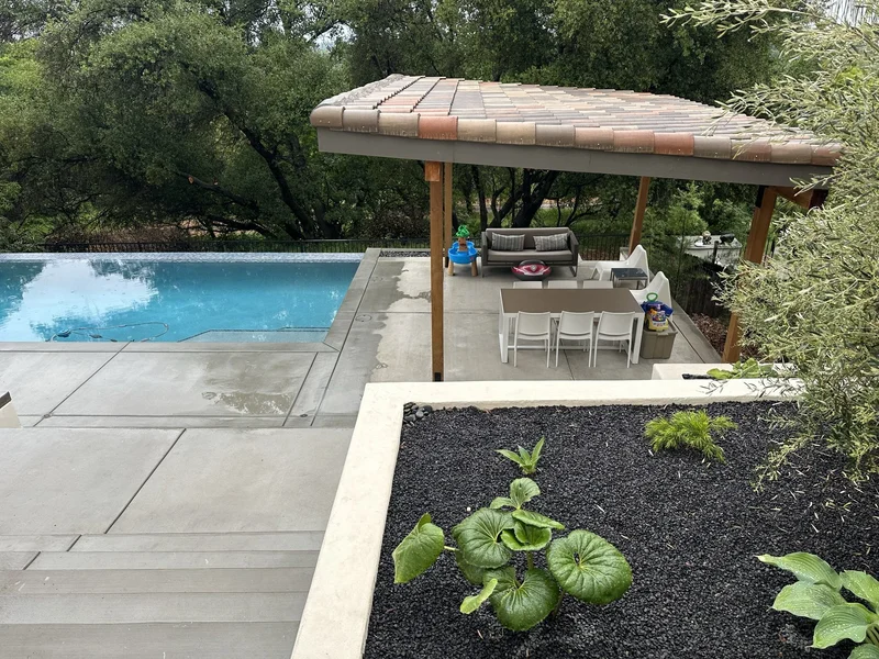 Pergola with a cushioned daybed overlooking the lap pool