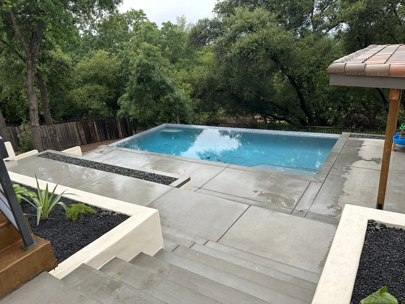 Finished poolside pergola with a concrete deck and lounge area