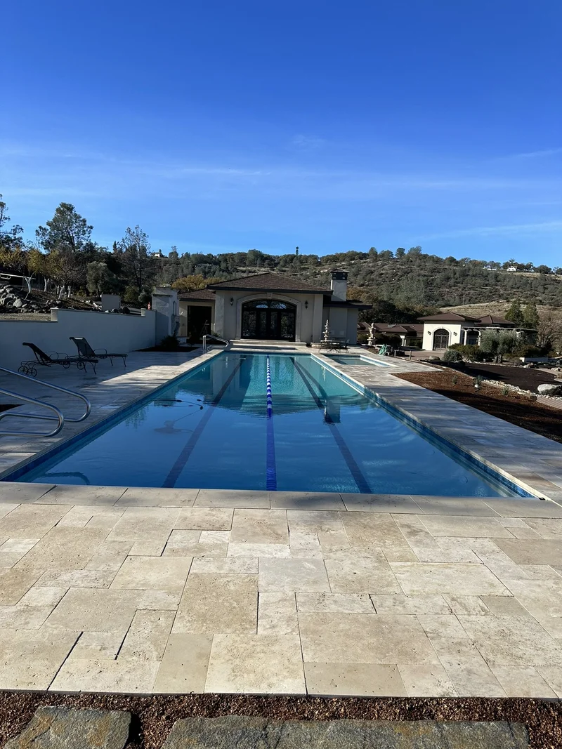Luxury pool deck blending concrete with turf transitions and a pergola