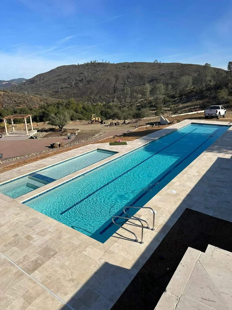 Aerial view of pool and spa with paver decking