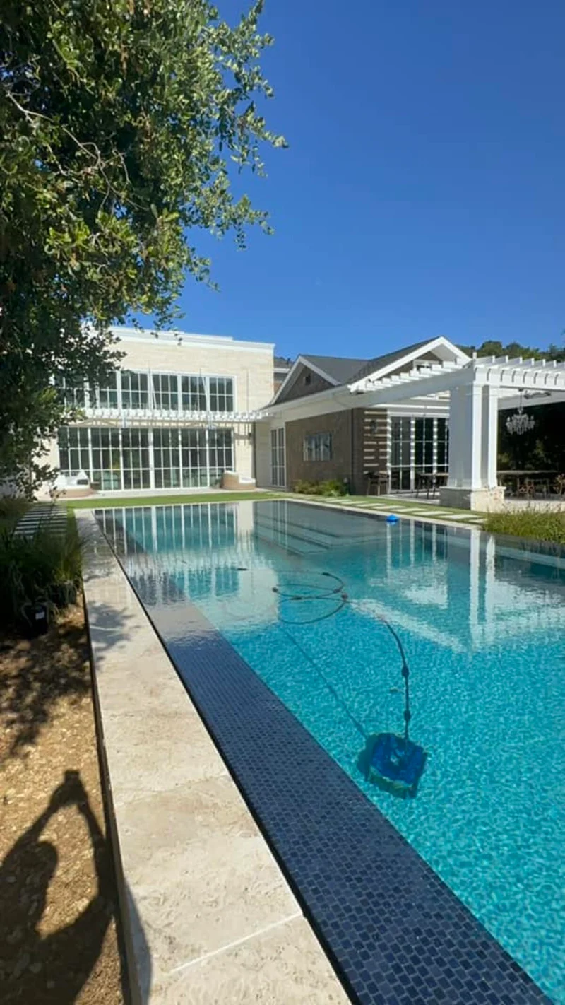 Pool with landscaped surroundings and estate home